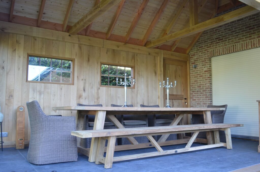 Landelijke buitenkeuken met lange houten tafel