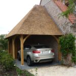 Carport met rieten dak tegen huis aangebouwd