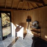 Binnenaanzicht houten guesthouse met invallend zonlicht