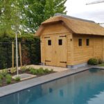 Houten poolhouse met rieten dak en boord in arduin