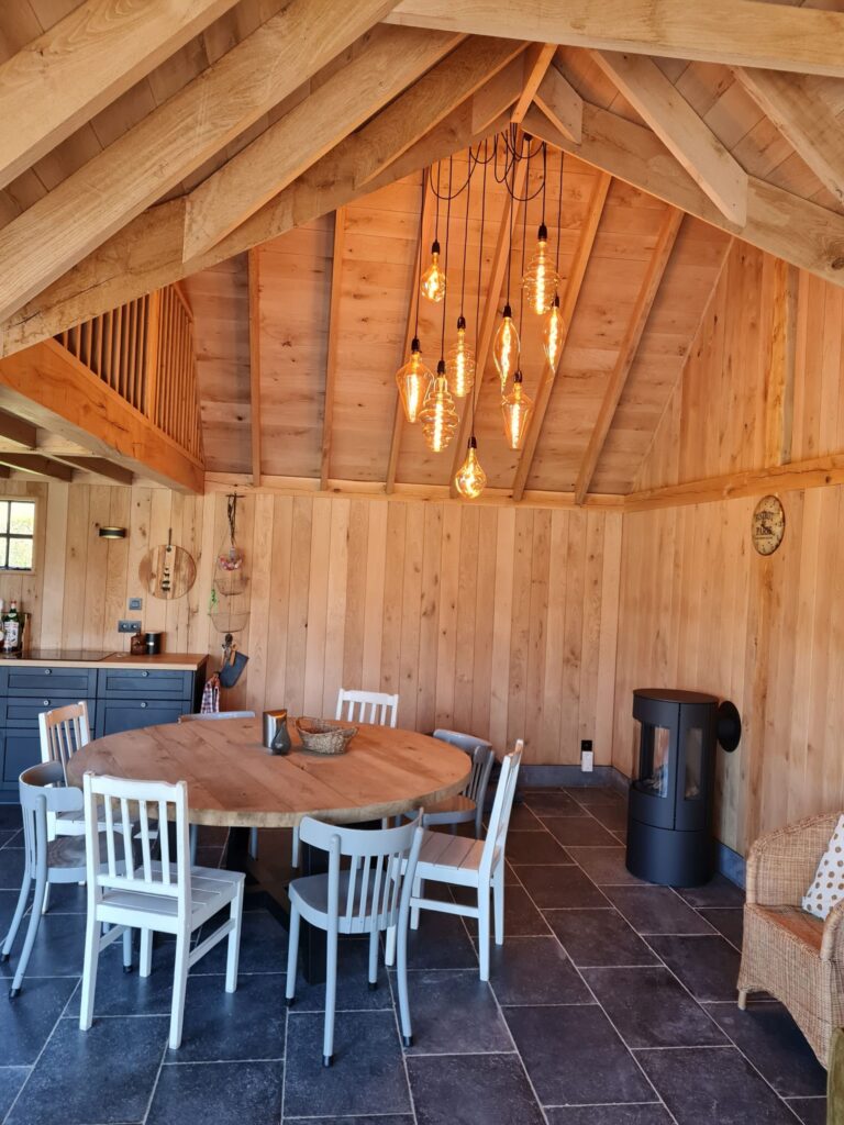 Binnenzicht in houten tiny house met ronde tafel en stoelen