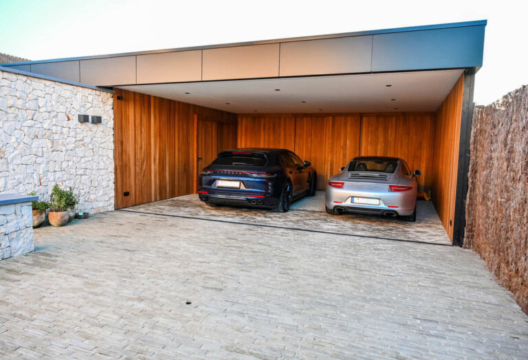 Carport met houten binnenafwerking en 2 Porsches eronder.