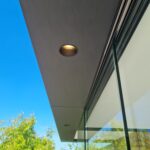 Detailaanzicht van de oversteek met spotjes bij een modern bijgebouw.