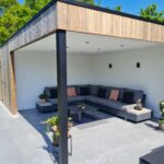 Houten terrasoverkapping met zithoek en tuinberging.