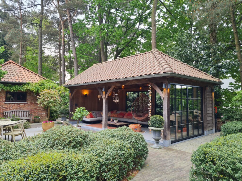 Eikenhouten terrasoverkapping en pannen dak. 1 gevel gesloten met glas.